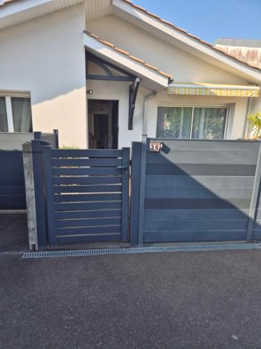 a blue fence in front of a house at La Gujannaise in Gujan-Mestras