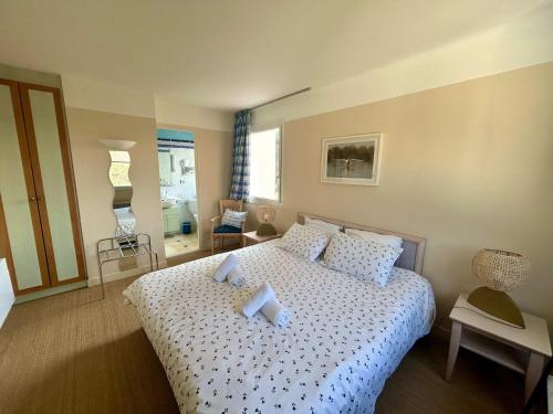 une chambre avec un lit avec des draps blancs et des oreillers dans l'établissement Seafront flat with indoor pool with stunning views, à Plestin-les-Grèves