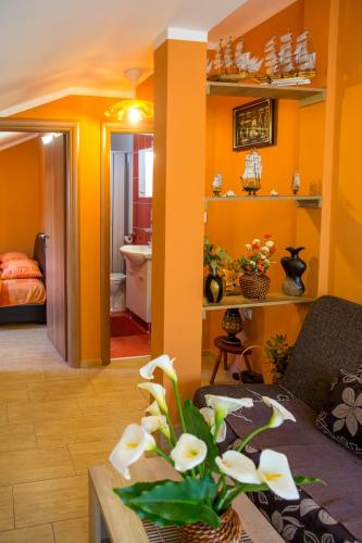 a living room with yellow walls and a table with flowers at Piano apartments in Kotor