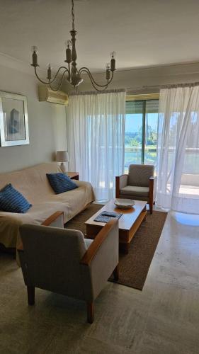 - une chambre avec deux lits, un canapé et une chaise dans l'établissement Saint-Laurent-du-Var Apartment à 2 pas du port, à Saint-Laurent-du-Var
