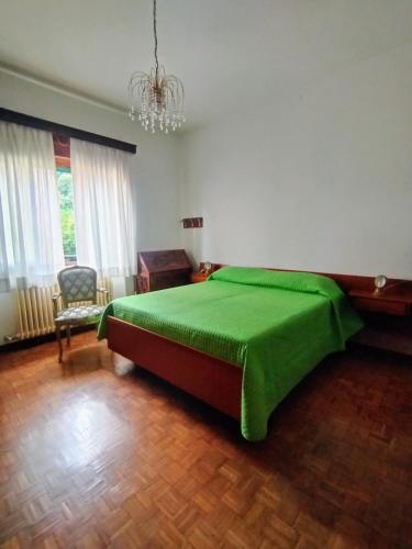 a bedroom with a green bed and a chair at La Mansardina in Menaggio