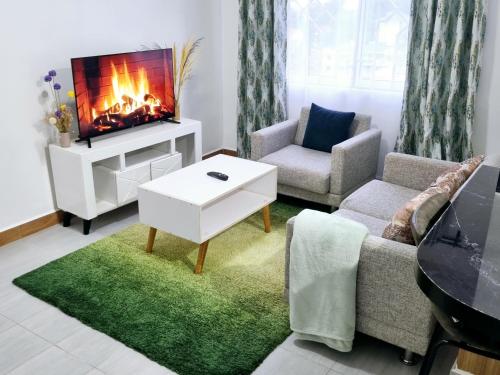 a living room with a couch and a fireplace at Marvel Homes in Meru