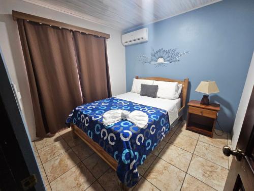a bedroom with a bed with a blue wall at Full equipado, WiFi, AC, vista volcán, 1er piso in Fortuna