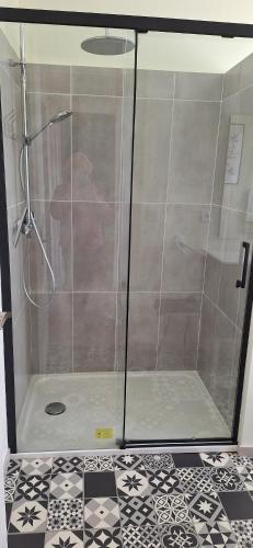 a shower with a glass door in a bathroom at Maison Paloumères in Ledeuix