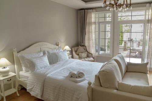 Un dormitorio blanco con una cama y una silla. en CastellStay, en Campson