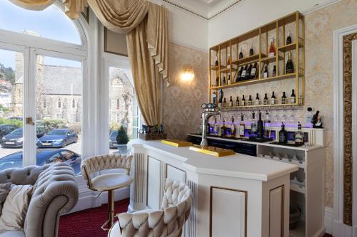 a bar in a living room with a window at The Annan Hotel in Llandudno