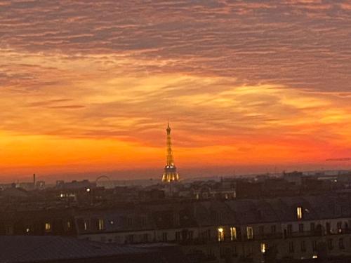 - une vue sur la tour Eiffel au coucher du soleil dans l'établissement Chambre avec vue Montmartre & Tour Eiffel, à Paris