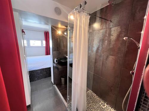 une salle de bain avec une douche avec un rideau de douche dans l'établissement VILLAGE NATURISTE - CAP d'AGDE - PORT NATURE 2 - VUE MER - COURSIVE, au Cap d'Agde