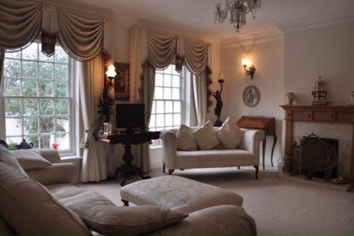 a living room with a couch and chairs and windows at Modern Regency Townhouse London in London
