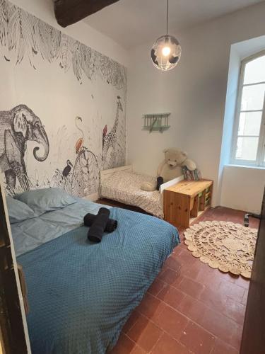 - une chambre dotée d'un lit bleu et d'une peinture murale dans l'établissement Charmante Maison T3 avec extérieur, à Coursan