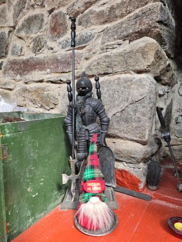 a statue of a person with a broom at Squealing Pig Bothy in Bragor