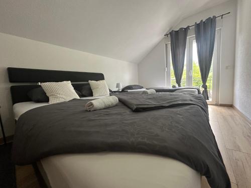 a bedroom with a large bed with black and white sheets at Magic Aria Bihac in Bihać