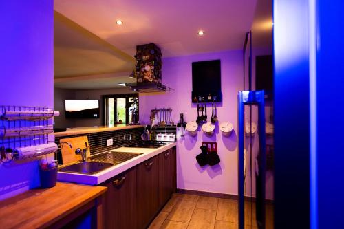 a purple kitchen with a sink and a refrigerator at Villa Panorama Pool & Garden in Trevignano Romano