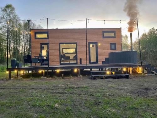 a small house with a deck with a grill at Tiny Silent House River in Zblewo