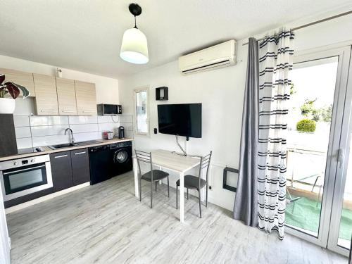 une cuisine avec une table et une télévision. dans l'établissement Nice Studio avec climatisation proche des plages, à Nice