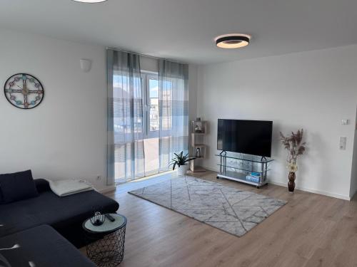 a living room with a couch and a flat screen tv at Ferienwohnung Dariana Schwalbach/Saar in Schwalbach