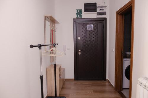 a hallway with a black door and a wooden floor at Lux 010 in Pirot