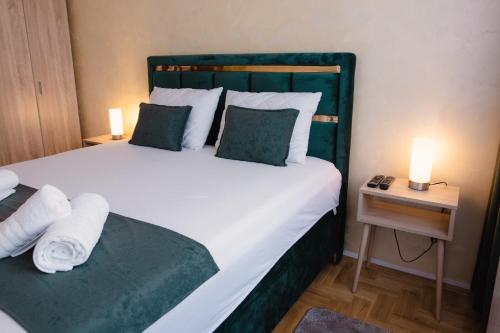 a bedroom with a large bed with a green headboard at Lux 010 in Pirot