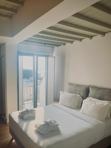 a white bed with two towels on top of it at Fabrikas in Mýkonos City