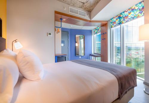 a bedroom with a white bed and a large window at Tru By Hilton Chillan Ferrat in Chillán