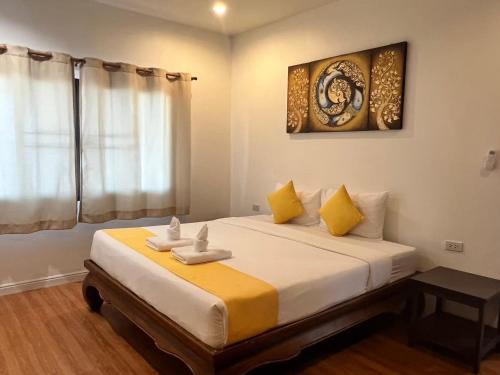 una camera da letto con un letto grande con cuscini gialli di Sunshine House By Serenity Sea House a Ban Khao Khwang (2)