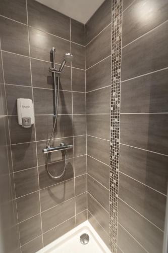 a bathroom with a shower and a tub at Cit'Hotel Les Alizes in Dinard