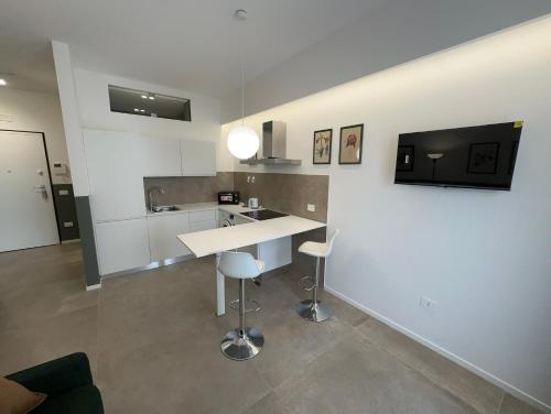 a kitchen with a counter and a sink and a tv at Luca's Home in Trani