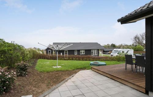 a backyard with a wooden deck and a house at 2 Bedroom Gorgeous Home In Haarby in Brunshuse