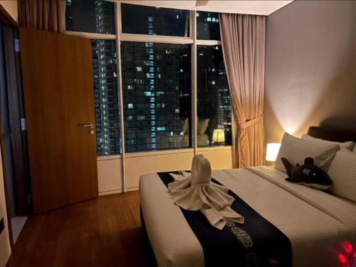a bedroom with a bed with two cats laying on it at Vortex Premium Apartment klcc in Kuala Lumpur