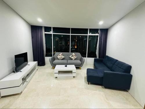 a living room with a couch and a tv at Vortex Premium Apartment klcc in Kuala Lumpur