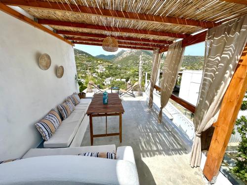 a living room with a couch and a table on a balcony at Babatseratsi skyrian studio 1 in Skiros