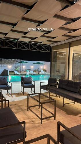 a room with benches and a swimming pool at Yaras villa in Ash Shāghūr