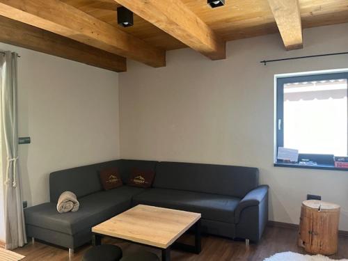 a living room with a couch and a table at Resort Biela Skala - CHATA Chopok Jasná Juh in Bystrá