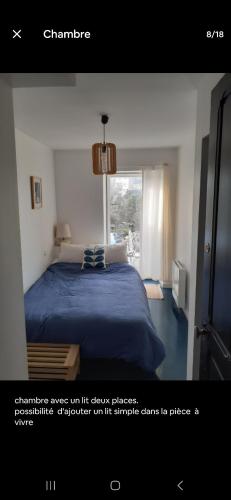 une chambre avec un lit bleu et une fenêtre dans l'établissement Havre de paix, à Rodez