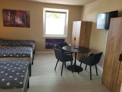a room with a bed and a table and chairs at HK-Vermietung in Brieselang