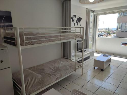 deux lits superposés dans une chambre avec fenêtre dans l'établissement Palavas studio vue mer, à Palavas-les-Flots