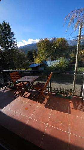 a picnic table and a bench on a patio at Departamentos Turísticos Saavedra in El Bolsón