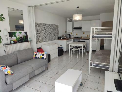 - un salon avec un canapé et des lits superposés dans l'établissement Palavas studio vue mer, à Palavas-les-Flots