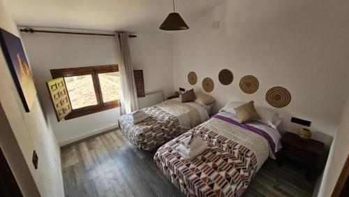 a bedroom with two beds and a window at Hostal Altajo con Restaurante, Naturaleza & Descanso en el Alto Tajo in Peralejos de las Truchas