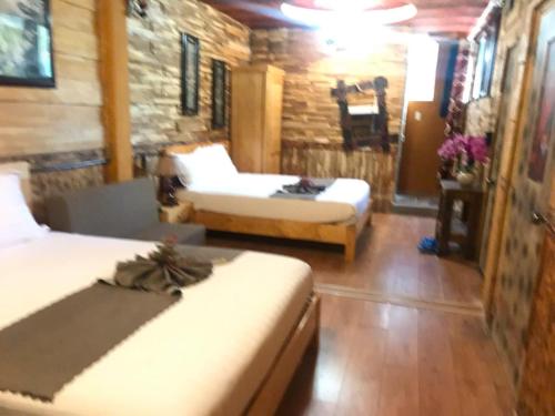 a living room with two beds and a couch at Redhouse Dalat Hotel in Da Lat