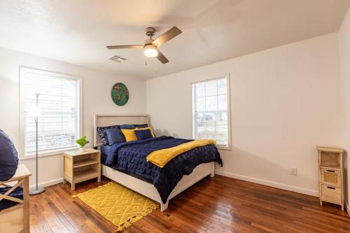 a bedroom with a bed and a ceiling fan at Two Homes - Charming Home and Cozy Bungalow in Tulsa