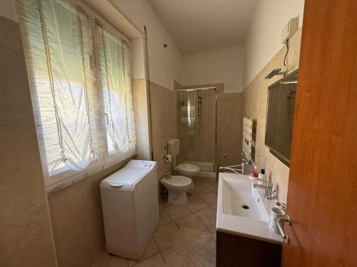a white bathroom with a toilet and a sink at Holiday Home Villanova in Ponte Lucano