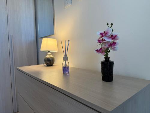 a table with a vase of flowers and a lamp at Holiday Home Villanova in Ponte Lucano
