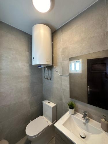 a bathroom with a toilet and a sink and a mirror at El Balcón de Villablancas in La Manga del Mar Menor