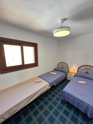a room with two beds and a window at El Balcón de Villablancas in La Manga del Mar Menor
