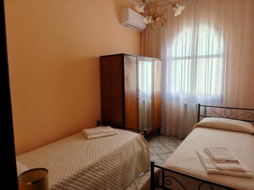 1 dormitorio con 2 camas, vestidor y ventana en M&M Home, en Trappitello