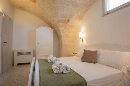 a bedroom with a bed with towels on it at Masseria Galleppa by Apulia Hospitality in Monopoli