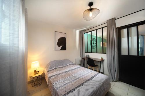une chambre avec un lit, un bureau et une fenêtre dans l'établissement Appartement tout équipé 6 à 8 couchages avec terrasse et parking, à Marseille