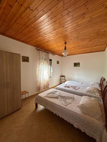 a bedroom with a large bed and a wooden ceiling at Holiday Home Zenit in Ulcinj