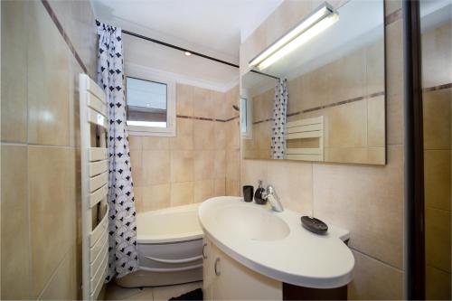 une salle de bain avec un lavabo, une baignoire et des toilettes dans l'établissement Appartement tout équipé 6 à 8 couchages avec terrasse et parking, à Marseille